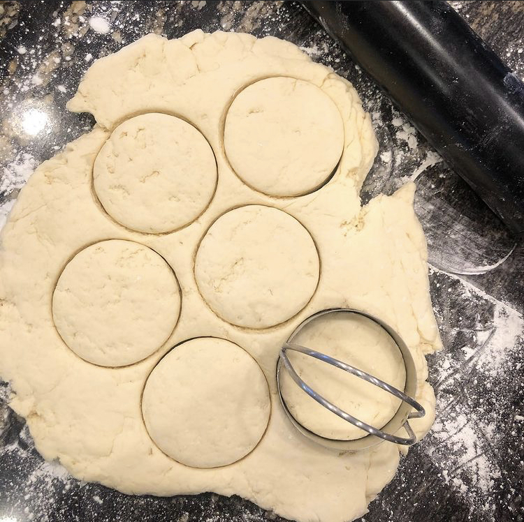 rolled out biscuit dough cut into circles, biscuit cutter, rolling pin