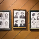 Three frames hang on a wall. Within each frame is a prison intake photo of a woman who served a sentence at the Kansas State Industrial Farm for Women. The first frame is black and contains four images of one woman. The second frame is gold and contains four prison intake photos, two of two different women. The final frame is green and contains four prison intake photos, two of two different women. The bottom right photo in this frame is blurry as the woman must have moved when the photo was taken.