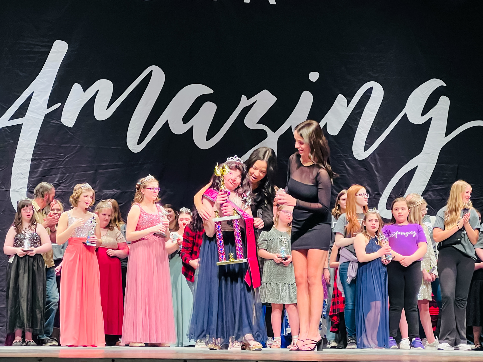A contestant is crowned and given a trophy at Miss Iowa Amazing, February 2023.