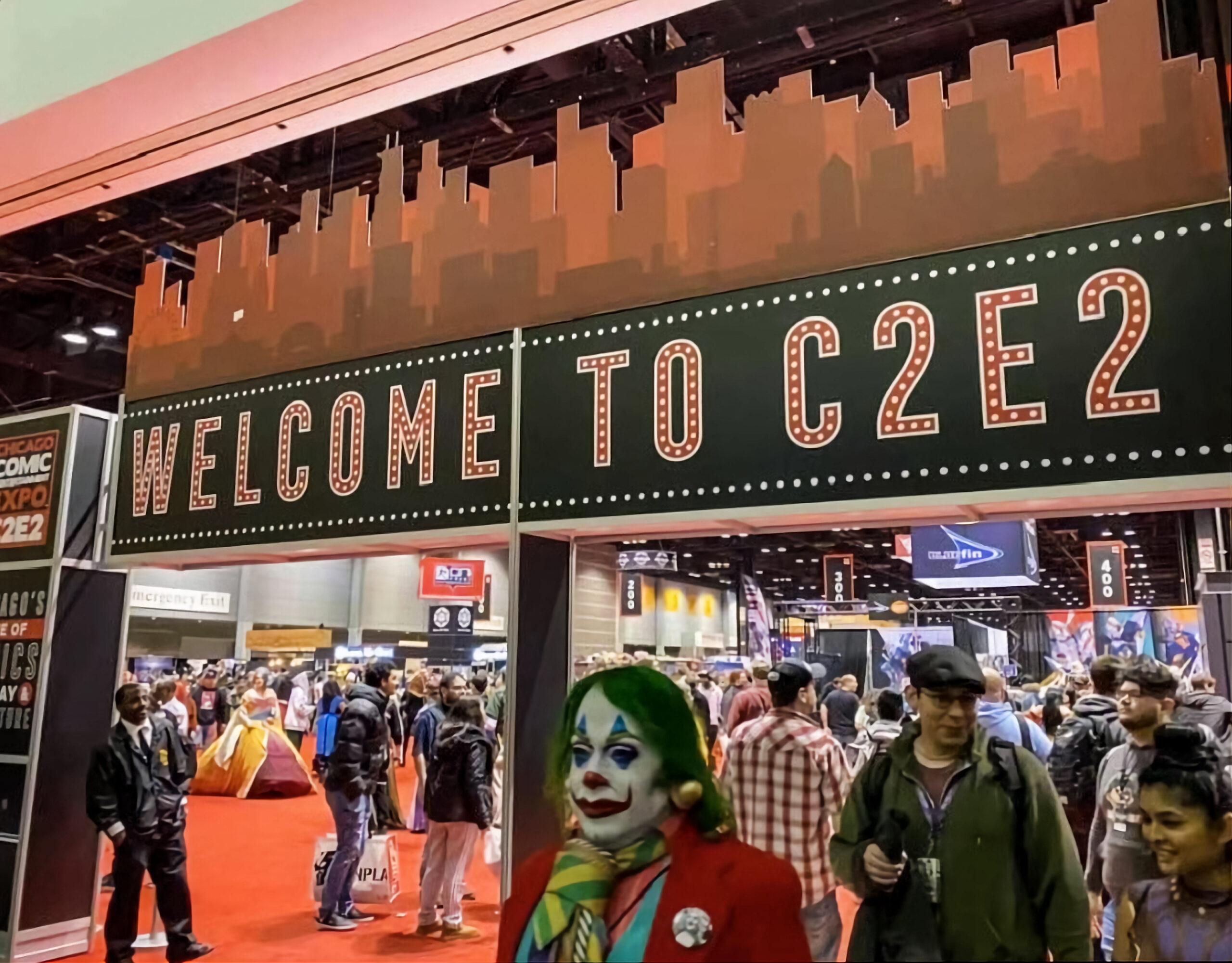 The C2E2 sign is above a crowd of people entering and exiting the event space.