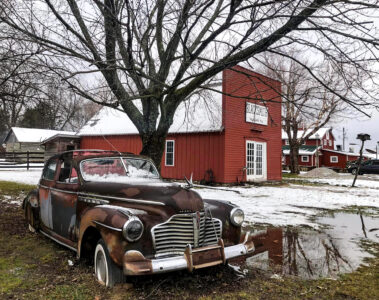 Lowell Davis’s grandfather's original blacksmith shop that Lowell had transferred to Red Oak II. Lowell Davis’s old automobile is also pictured.