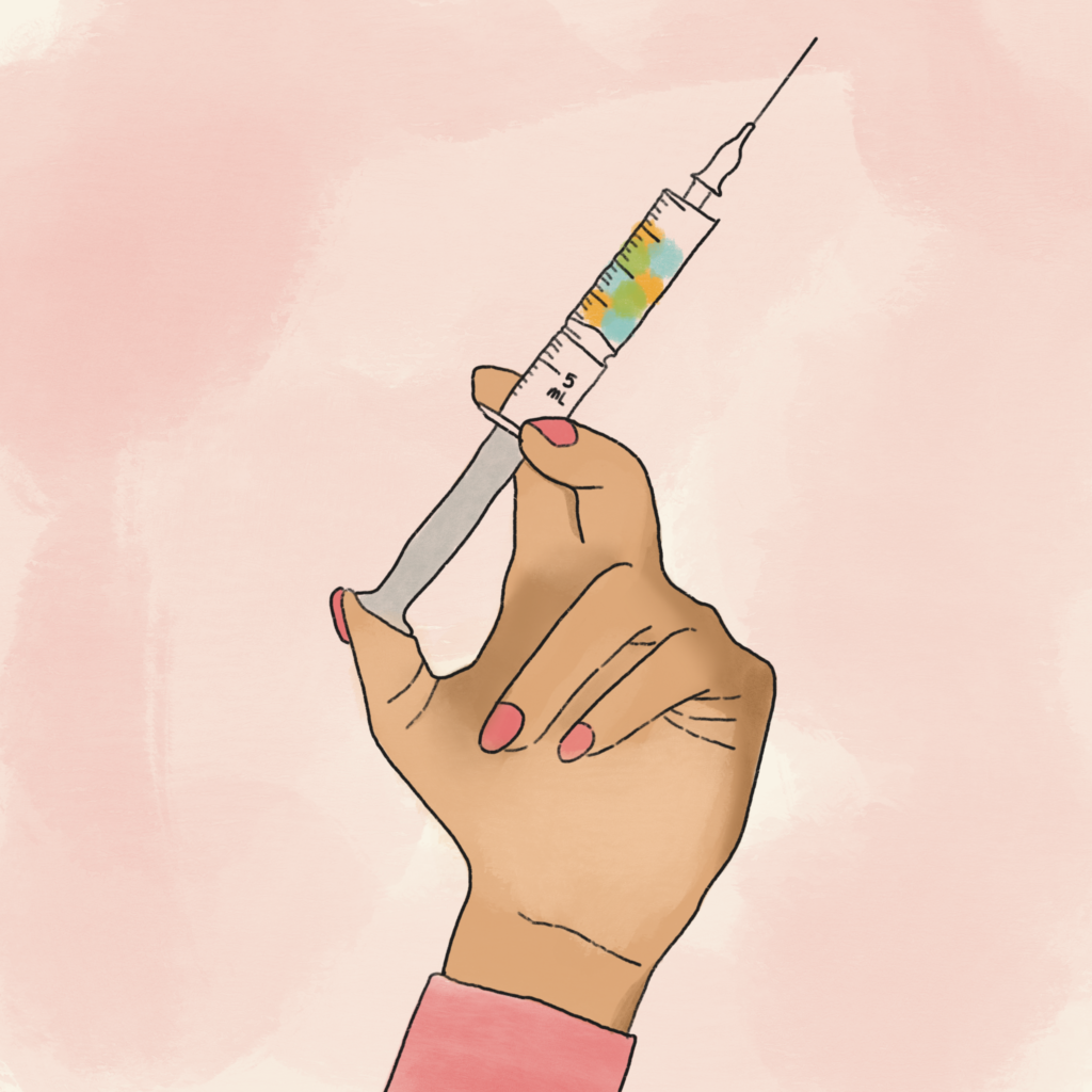 A woman is holding a syringe in her hand with the syringe filled with various colors of blue, green and orange. 
